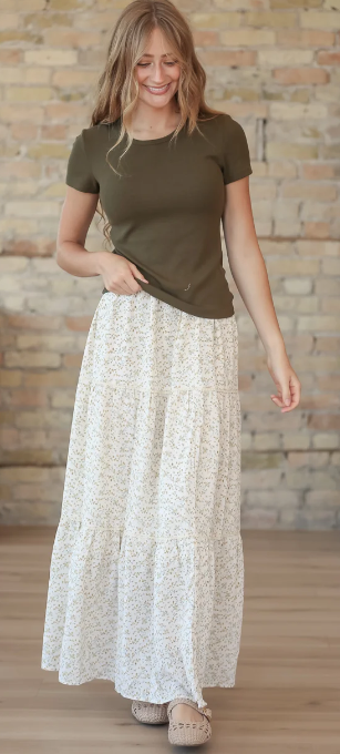 a teen girl wearing a long white maxi skirt from inherit co