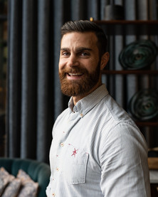 Ett personalporträtt föreställande en man med vit skjorta och skägg