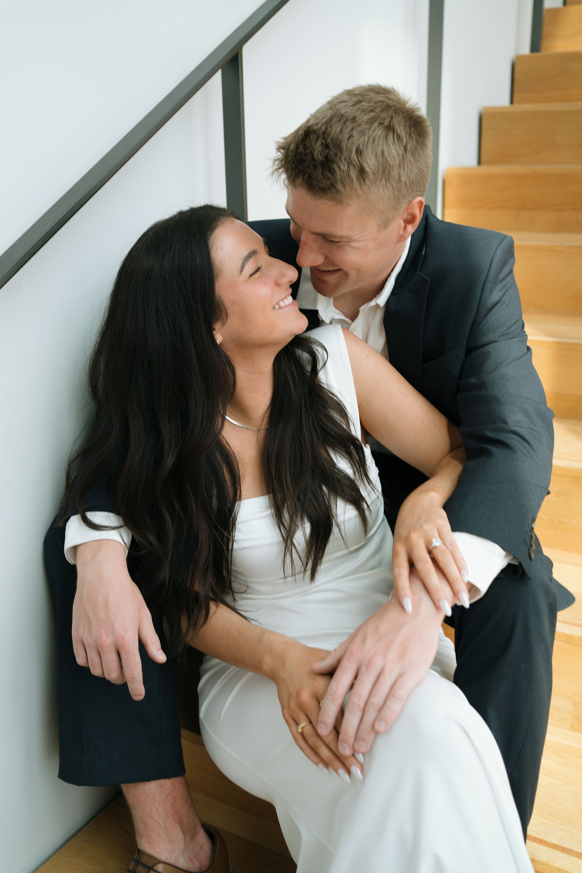 engaged couple sitting on stairs