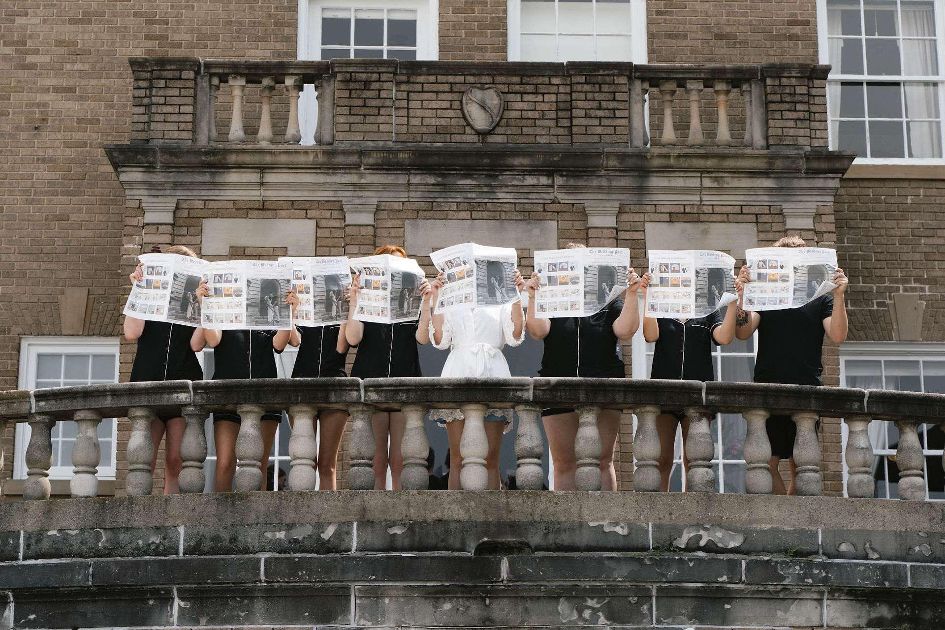 bridesmaids holding newspapers