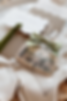 A decorative, white napkin holds a wrapped cookie with a house image and green bow. Papers say "Dine" and "A taste of our home" in background.