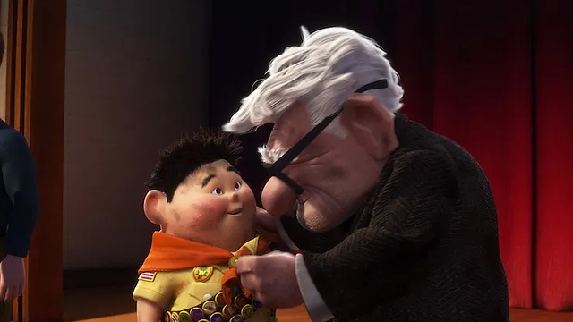 old man pins scout button on boy's sash