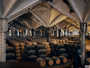 Interior de una bodega de Jerez con techos altos y numerosas botas de vino