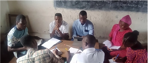 Group of people studying together at table with bibles and notebooks.