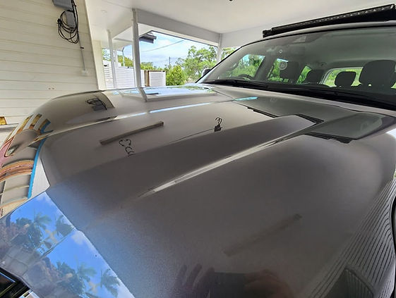 Mirror-like reflection after multi-stage paint correction restoring gloss and depth to black paintwork.