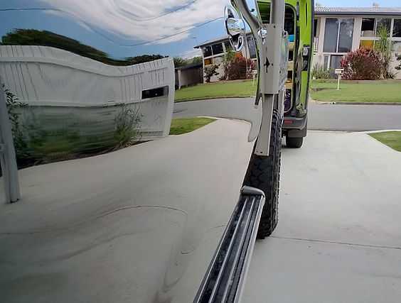 Professional paint correction restoring deep gloss and mirror reflections on black 4WD