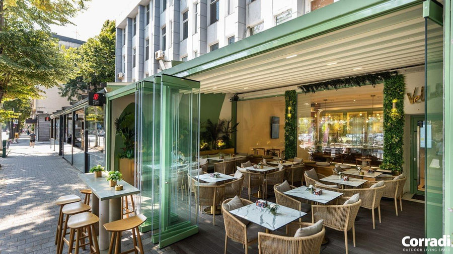 Restaurant terrace wit rope garden furniture sets and retractable roof system and glass bifold doors.