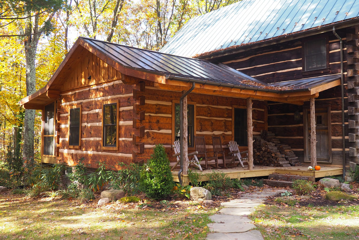 A hand hewn live edge log addition built with dovetail notches.