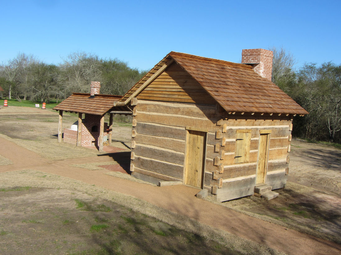 A small live edge oak log cabin with saddle notches.