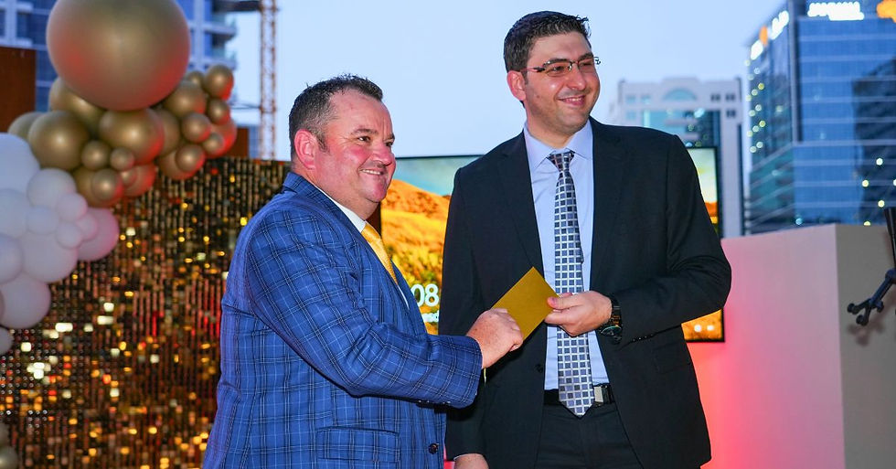 Gateway Group’s CEO, Nathan Hunt, awards golden ticket to longest serving employee, Salah Al Khatib, PRO.
