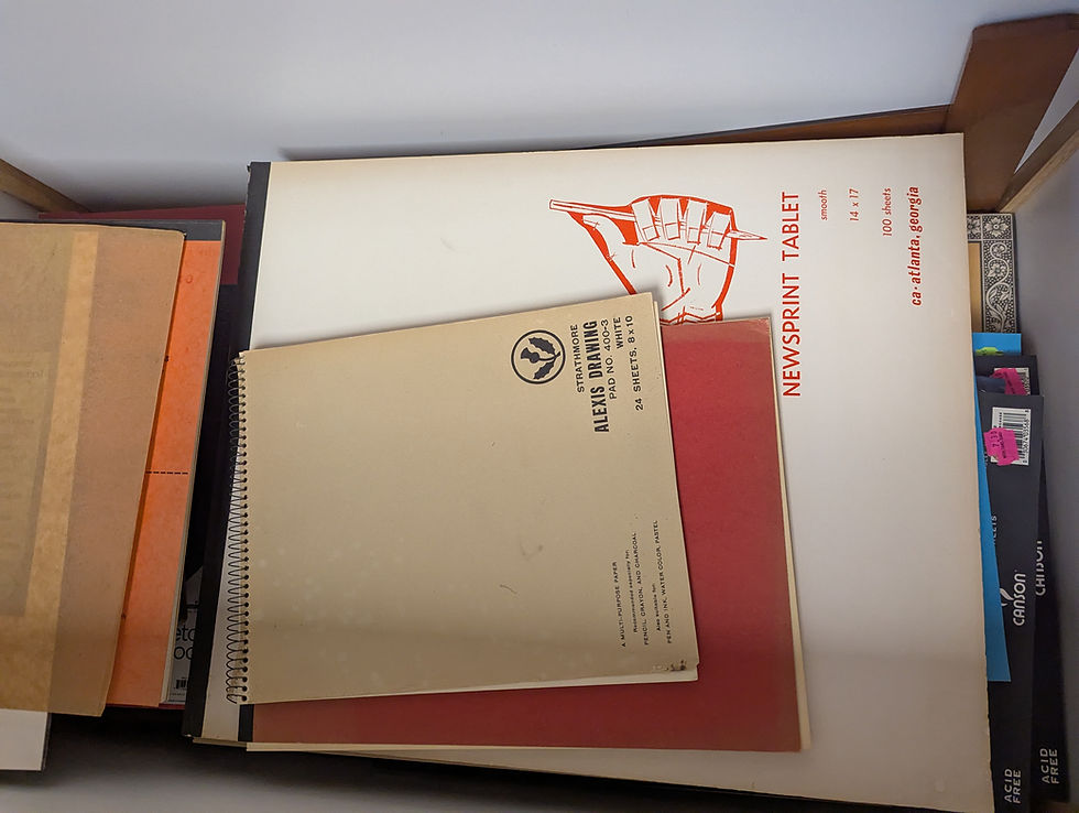 papers and drawing pads in a box