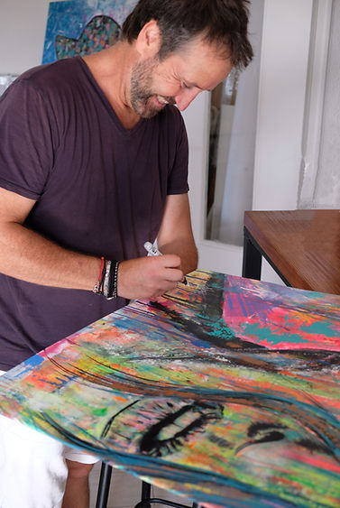 L'artiste Ugo Damiani en train de signer une oeuvre d'art