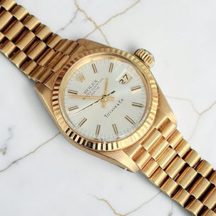 a vintage rolex lady datejust 26mm with a tifanny stamped dial. timepiece is in full yellow gold and features a fluted bezel and president bracelet. fourfourwatches