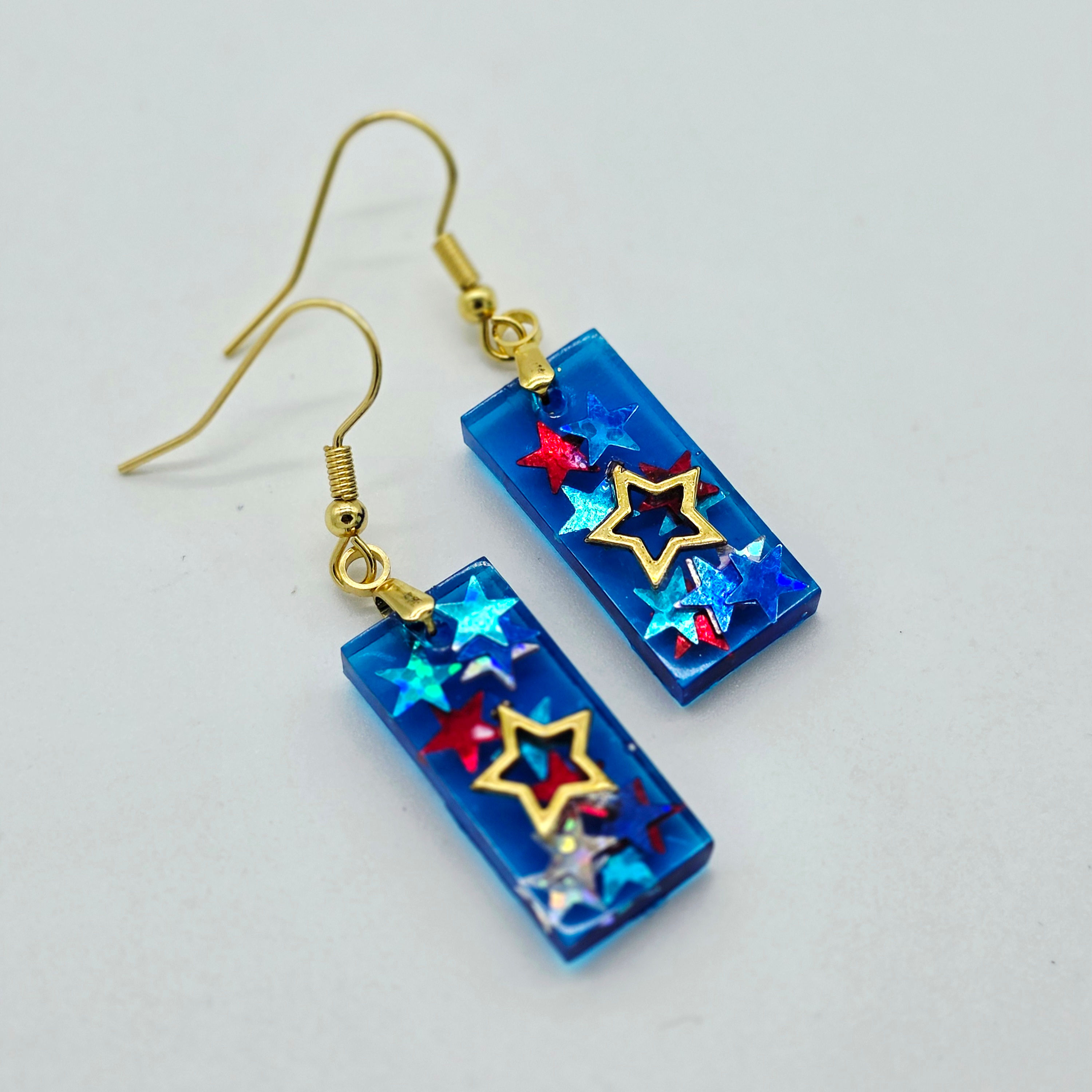 Resin Earrings - Gold metal star, star glitter, blue background