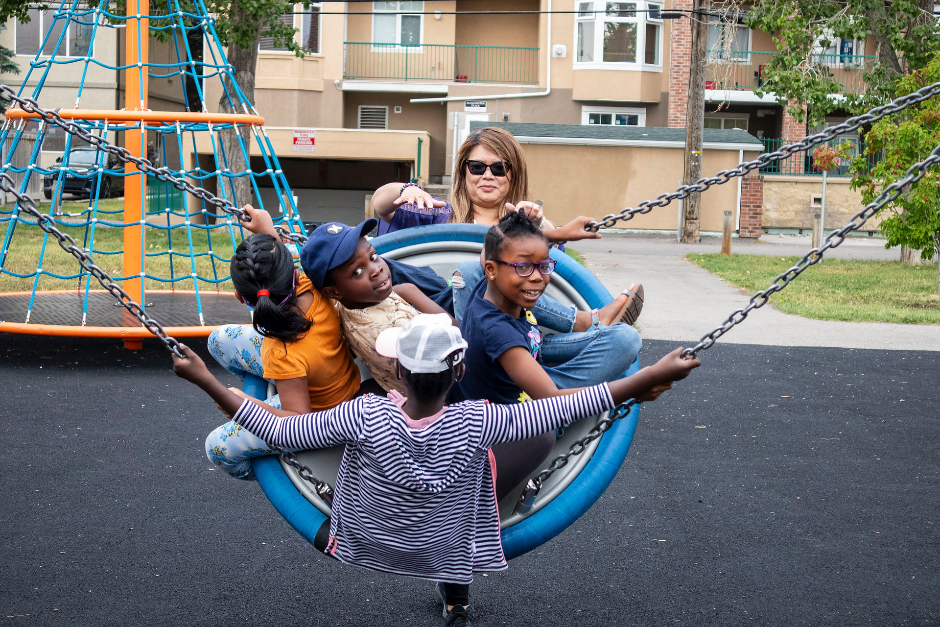 group of kids on swing being pushed