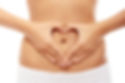 Naked torso with 2 hands focused in a heart shape around belly button