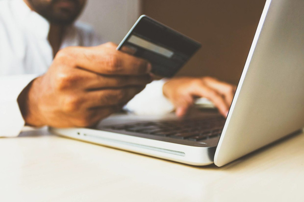 man purchasing something on a laptop - How to Improve Conversion Rates