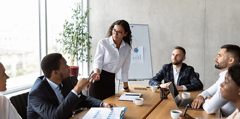 businesswoman-on-business-meeting-talking-with-colleagues-standing-in-office.jpg