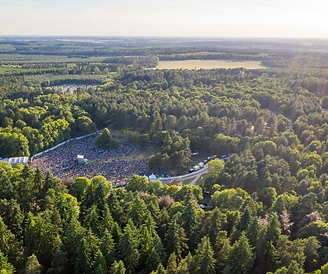 Aerial view of a large outdoor concert in the Thetford forest, UK.