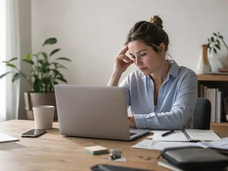 Femme travaillant sur ordinateur, visiblement sous tension face à l'accumulation du stress quotidien.