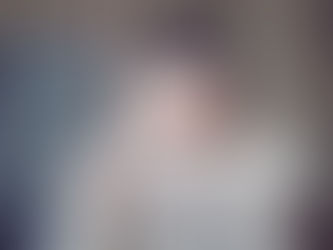 Femme aux yeux bleus cachant son visage avec un pull beige tricoté. Mur de béton en arrière-plan, expression mystérieuse. Photo pour illustrer le programme de régulation du nerf vague Alphazen