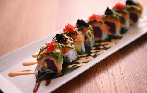 Sushi roll with salmon, avocado, and caviar served on a white plate Sushi Ginza