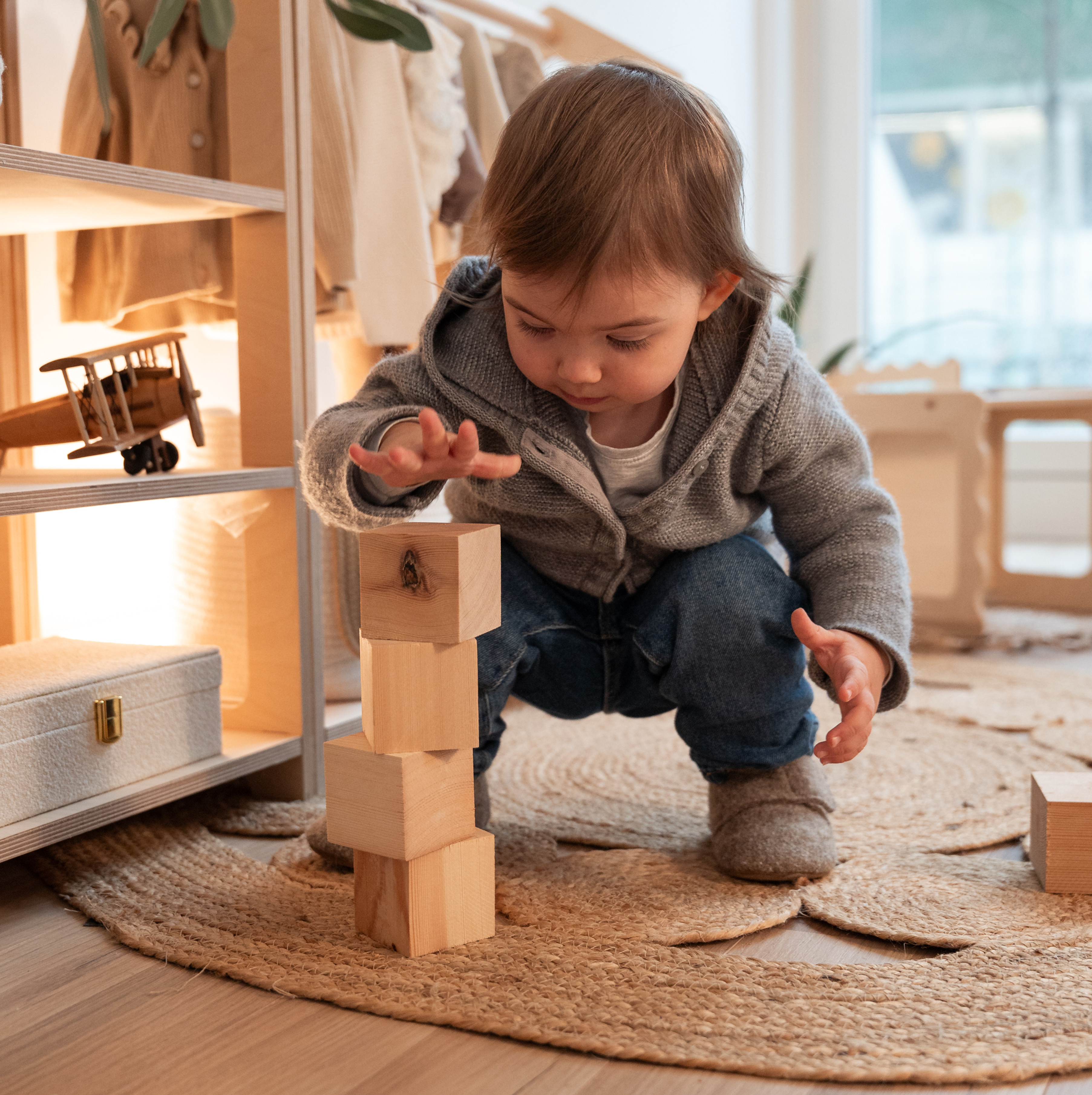 Altersgerechte Spielzeugaufbewahrung nach Montessori mit Kleiderstange und Regal.