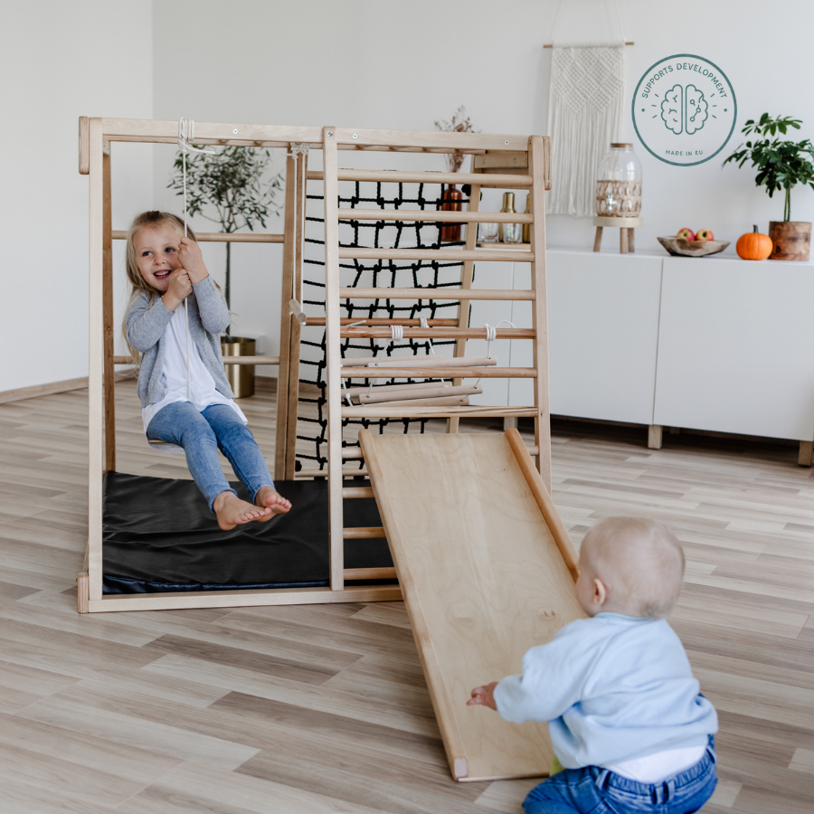 Zwei Kinder spielen am CLIFF Klettergerüst mit SCHEIBENSCHAUKEL und Holzrutsche