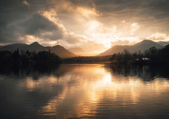 Sunset over Derwentwater with silhouette of mountains in the background