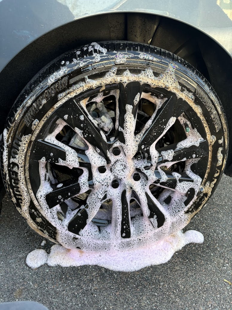 Soapy wheel of a sedan during exterior cleaning