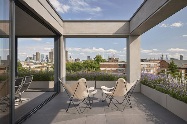 Looking through the pergola-framed terrace at Clerkenwell Rooftop towards the City of London skyline.