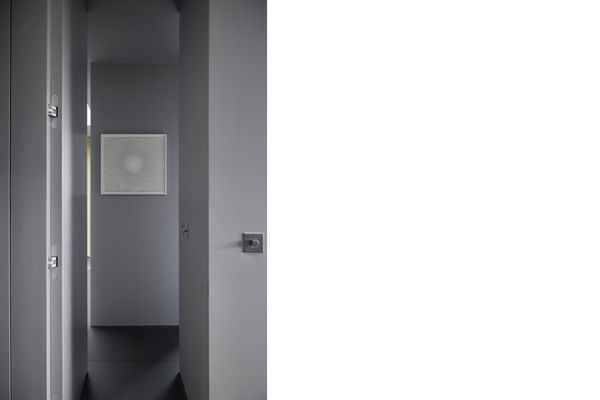 Looking from the hallway into the bedroom at Clerkenwell Rooftop, with the hallway walls framing the print on the dividing wall between the dressing area to the left and sleeping area to the right.