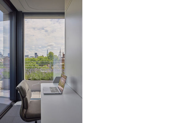 Study at Clerkenwell Rooftop, with a desk cantilevered from the timber-clad monolith and the City of London skyline visible through the full-height glazing beyond.