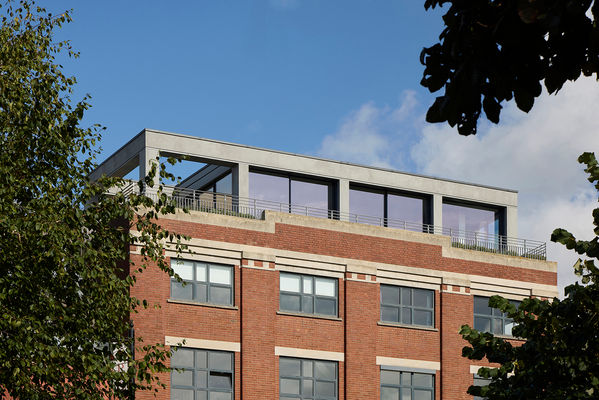 Closer view of Clerkenwell Rooftop from the park through trees, with the external shading shutters fully retracted and concealed within the façade.