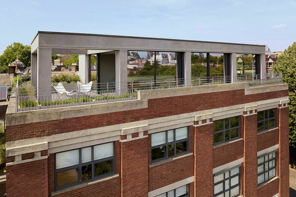 Elevated view of Clerkenwell Rooftop, showing the penthouse with an open pergola-framed terrace and wrap-around planting above the former industrial building.
