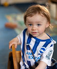 Little boy in blue & white football top at Kids in Bloom Nursery, Liverpool