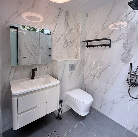 Space-saving white bathroom vanity and mirrored medicine cabinet with internal storage for Singapore condo renovation by Cosmos Decor.