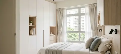Cozy and minimalist bedroom design featuring integrated wardrobe storage and warm lighting, a hallmark of bto renovation expertise by renovation contractor Singapore firm, Cosmos Decor.