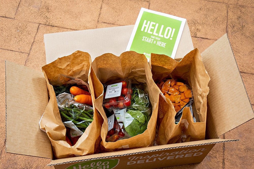 vegetables in brown paper bags inside a delivery box