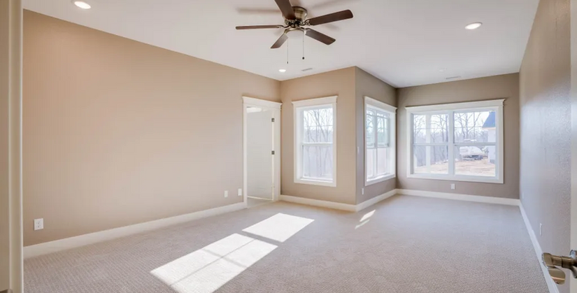 Spacious master bedroom in a Porto Cima home by Cloke Custom Homes, filled with natural light and luxury finishes