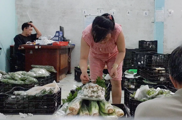 Staff putting VietGAP labels on vegetables gathered from markets (thanhnien)