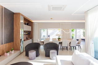 sala e sala de jantar amplas e espaçosas, há uma bela mesa e poltronas, o ambiente é predominantemente branco, e amplamente iluminado e decorado, essa fotografia foi produzida para um corretor de imóveis para marketing imobiliário.