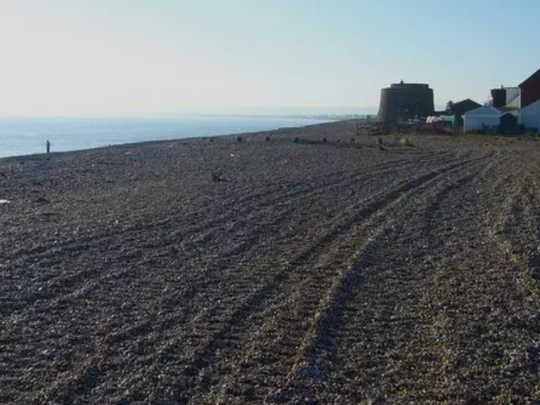 Police swamp quiet beach after woman's body washes up on shore - probe into who she was 