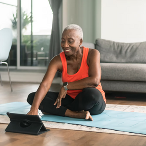 Image of a woman sitting in her living room on a yoga mat