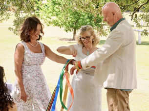 Celebrant Events performing handfasting ritual with couple at wedding in garden