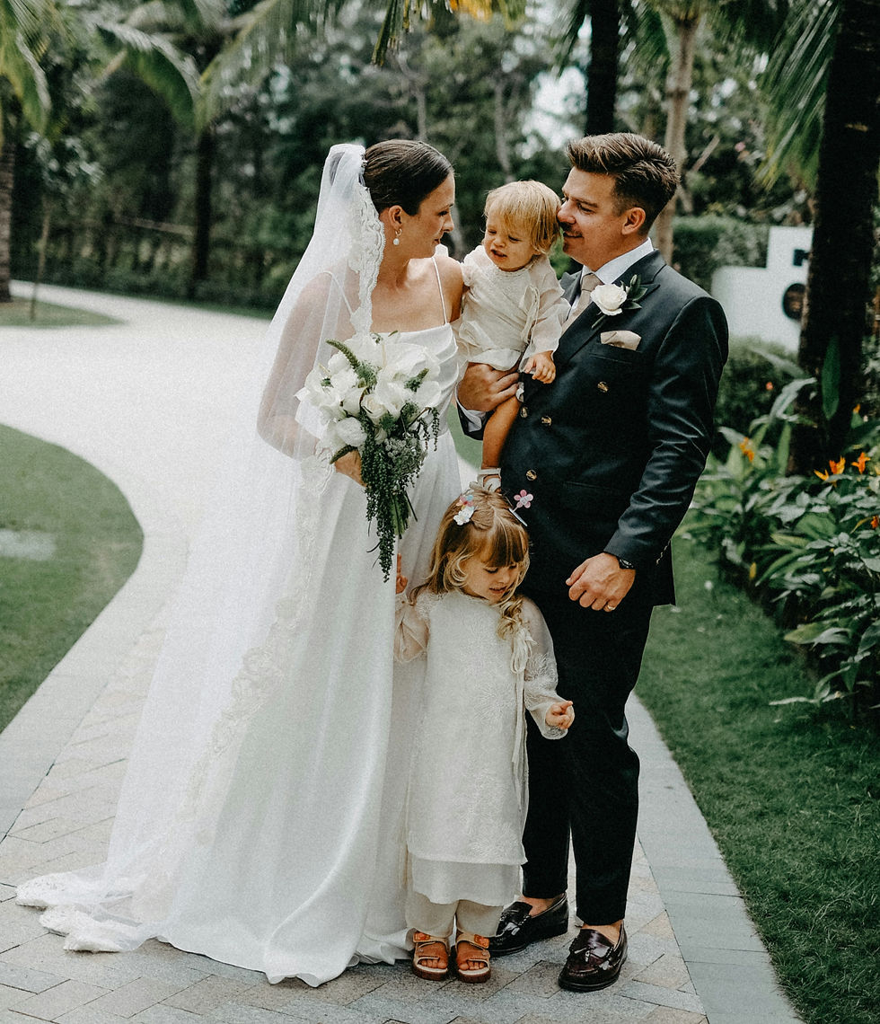 Couple getting married in beautiful gardens with their young children attending 