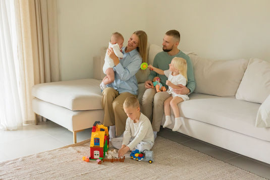 a happy family sitting in a couch in the new benbrook, texas home