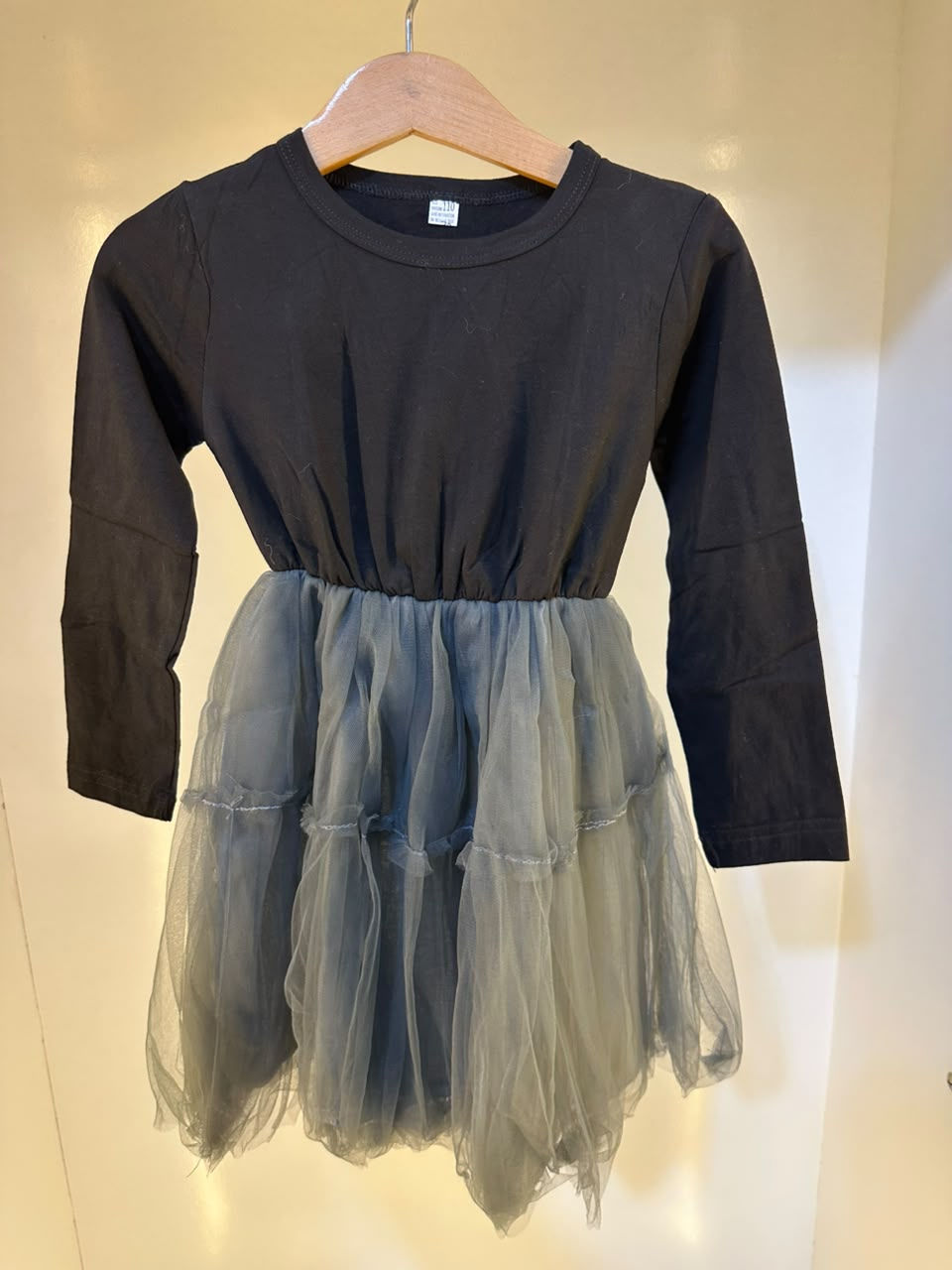 Beautiful girls’ party-style dress featuring a classic black long-sleeve top wit