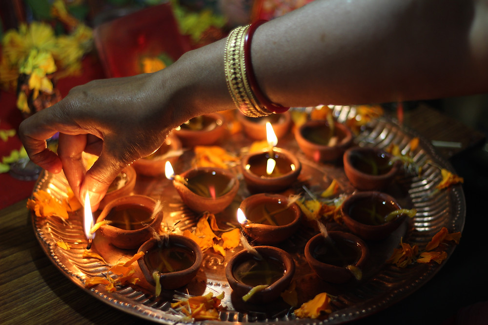 Lighting Diya during Diwali Puja. Articles on Meditation, Mindfulness, Nonduality and Integrated Healthcare written by Dr. Vikas Pandey