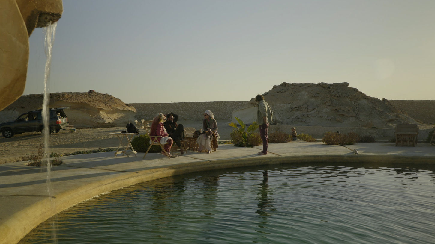 A group of visitors relax by the pool at Al Nyhaya Spring in Siwa, Egypt on Sauna Channel.